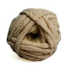 Ball of beige yarn on a white background